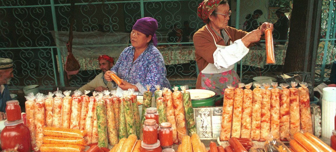 Women prepare, package and sell food at a market.