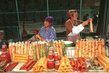 Women prepare, package and sell food at a market.