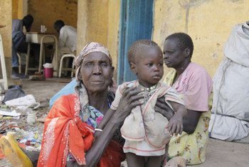 An elderly woman holds her grandson while his mother prepares food at a secondary school in Malakal, capital of Upper Nile state, South Sudan.