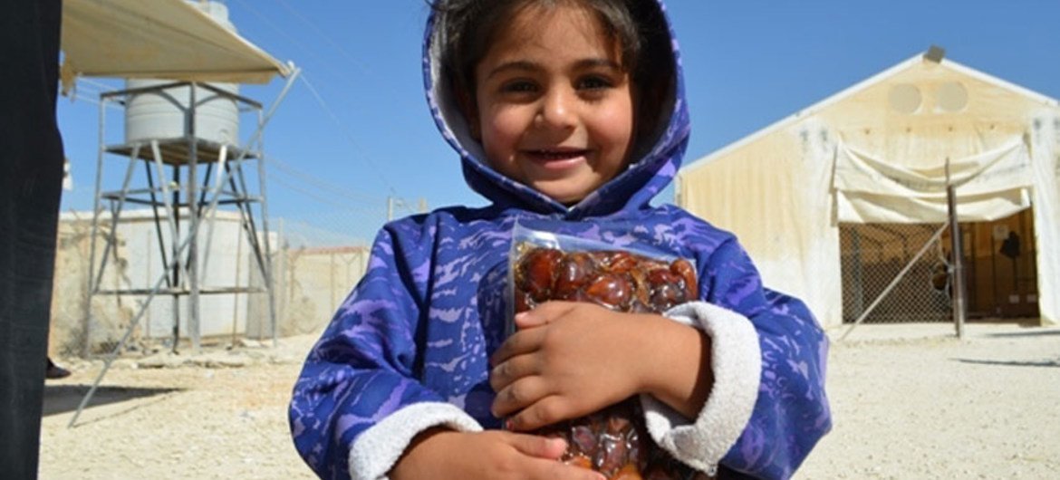 الأردن، مخيم الزعتري - فتاة صغيرة تلقت التمر المقدم من برنامج الأغذية العالمي. تصوير: برنامج الأغذية العالمي / دينا