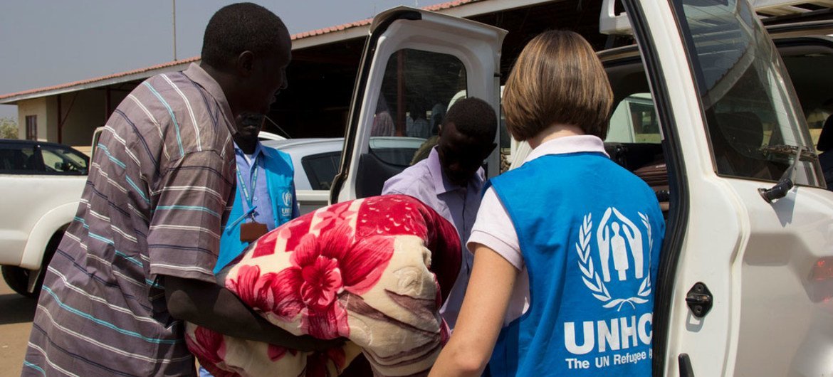 احد موظفي الأمم المتحدة يقوم بمساعدة لاجئ من دارفور تقطعت به السبل في بانتيو بجنوب السودان.