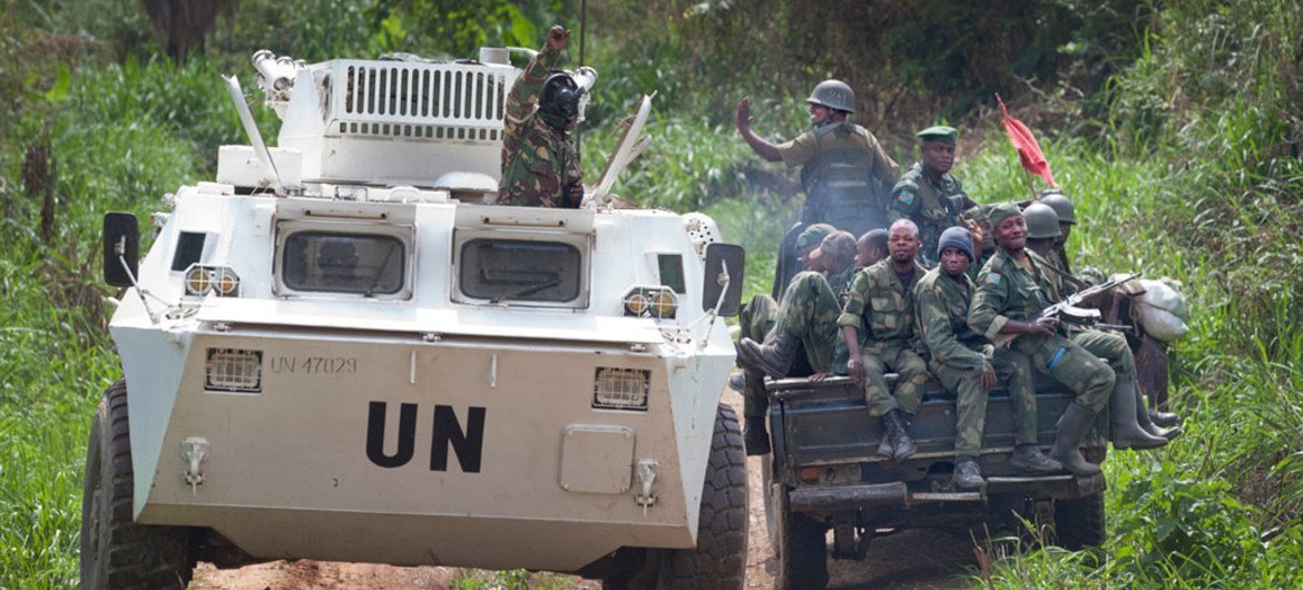 A MONUSCO APC is greeted by FARDC soldiers on their way back from the front line in the Beni region.