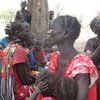 Displaced women and children under a hot sun in South Sudan's Maban County, where food shortages are causing tension.
