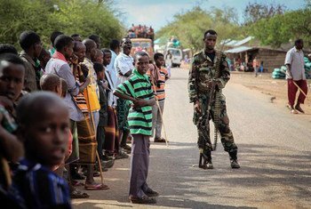 Residents of the village of Modmoday, 40 kilometres east of the town of Baidoa, Somalia, look on as a soldier of the Somali National Army (SNA) keeps guard.