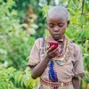 Au Kenya, une fillette Masaï lit un texte sur son téléphone portable. Photo Worldreader