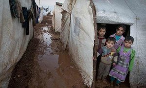 Syrian children stand in the entryway of their tent shelter in the Bab Al Salame camp for internally displaced persons in Aleppo Governate.