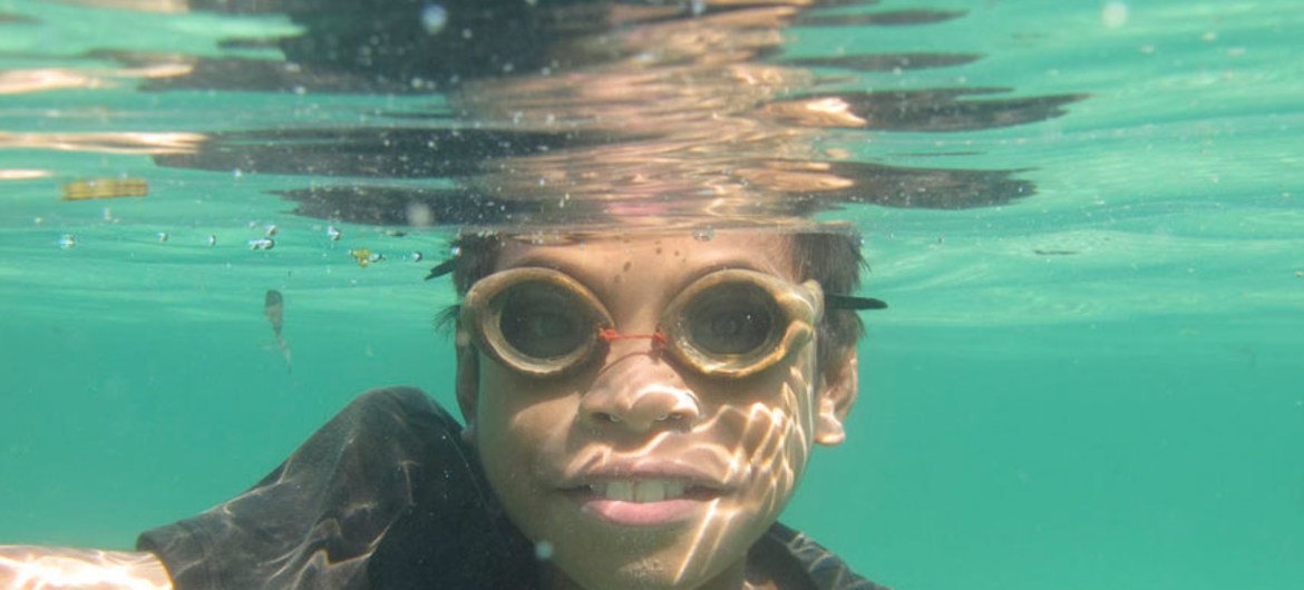 Young Timorese fisherman wearing his wooden goggles to catch fish along the shores of Atauro island off Dili.