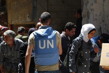 Un employé de l'UNRWA assiste des civils avec de l'aide alimentaire à Yarmouk, à Damas, en Syrie. Photo UNRWA