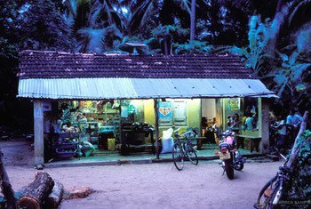 Un magasin dans un village au crépuscule au Sri Lanka éclairé par des panneaux solaires.