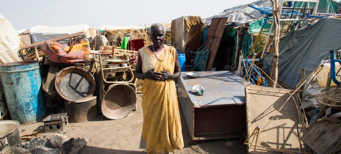A woman stands among her belongings in Renk, Upper Nile State, South Sudan.