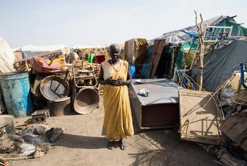 A woman stands among her belongings in Renk, Upper Nile State, South Sudan.
