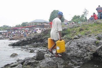 At the border with Rwanda, a resident of Goma, Democratic Republic of the Congo (DRC), collects water from Lake Kivu.