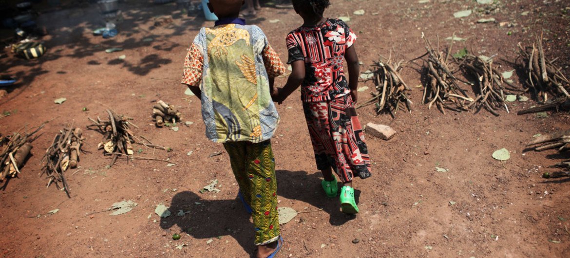 Two small children walk hand-in-hand in the Castor Church displacement camp in Bangui, the Central African Republic capital.