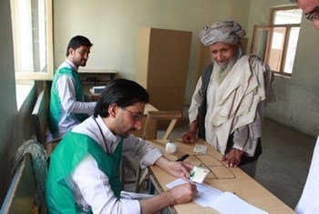 Des agents électoraux en Afghanistan aident un électeur lors du second tour du scrutin présidentiel le 14 juin 2014. Photo MANUA/Shamsudding Hamedi