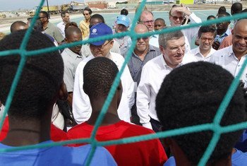 Secretary-General Ban Ki-moon (blue cap) chats with young Haitians at the opening of  the Sports for Hope Centre.