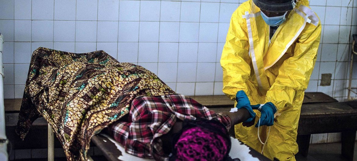 A government health worker at the Kenema Ebola Treatment Centre in Sierra Leone attends to a victim.