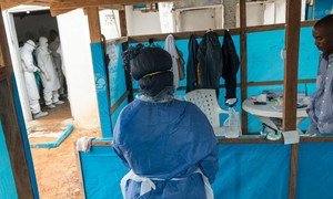 A woman waits to enter an  isolation ward to visit her husband, along with Liberian Ministry of Health, WHO, and Médecins Sans Frontières (MSF) personnel who are treating several Ebola patients located in the capital Monrovia.