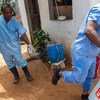 Dans la capitale du Libéria, Monrovia, un employé du Ministère de la santé asperge les chaussures d'un collègue dans une clinique d'isolement de malades d'Ebola, alors qu'il s'apprête à emmener des échantillons sanguins pour des tests. Photo MINUL/Staton 