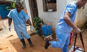 In the Liberian capital Monrovia, a Ministry of Health employee sprays the sole of a colleague’s shoes at an Ebola Isolation Clinic, supported by the World Health Organization and Médecins Sans Frontières (MSF), as he prepares to leave the facility to carry blood samples to be tested.