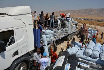 人道工作人员正在卸载货车，这些物资将提供给伊拉克的流离失所者。 难民署图片/E. Colt