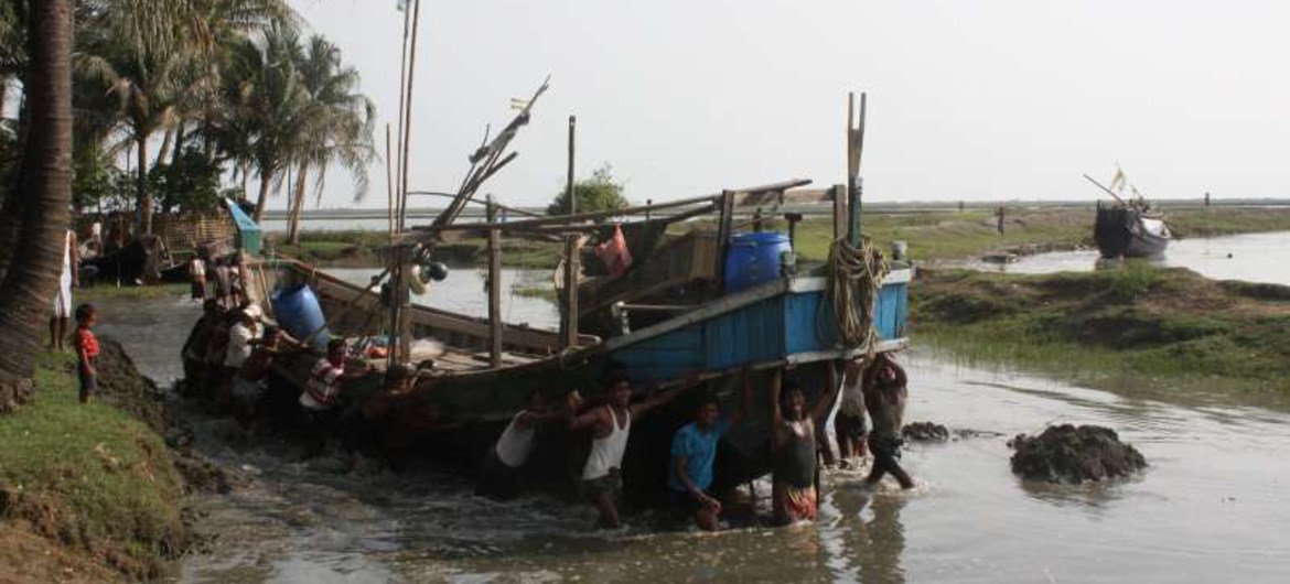 Fishermen manoeuvre a boat in a waterway near Sittwe in Myanmar. People risking their lives to leave Myanmar and cross the Bay of Bengal board boats in locations like this.