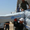 تفريغ شاحنات محملة بمئات الخيام لعائلات نازحة في العراق.الصورة: UNHCR/E. Colt