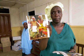 Une femme montre une photo de survivants qui ont quitté le centre de traitement d'Ebola à Kenema, en Sierra Leone. Photo UNICEF/Jo Dunlop