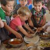 الأطفال من الأقلية اليزيدية يتناولون وجبة من الأرز والطماطم في قرية في اقليم كردستان، 2014 / سبتمبر أيلول. المصدر: المفوضية السامية لشؤون اللاجئين / ن. كولت