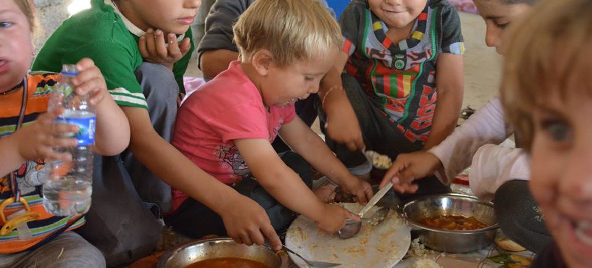 In Khanke village, Iraq Kurdistan Region, children from the Yazidi minority eat a meal of rice and tomato stew for lunch.