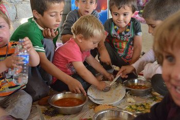 Dans le village de Khanke, dans la région du Kurdistan iraquien, des enfants de la minorité yézidie mangent un repas fait de riz et de tomates. Photo HCR/N. Colt
