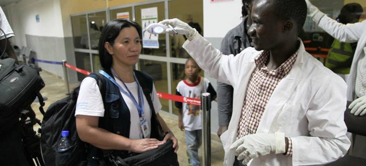 A WHO staff gets her body temperature checked at Lungi Airport, Freetown, Sierra Leone.