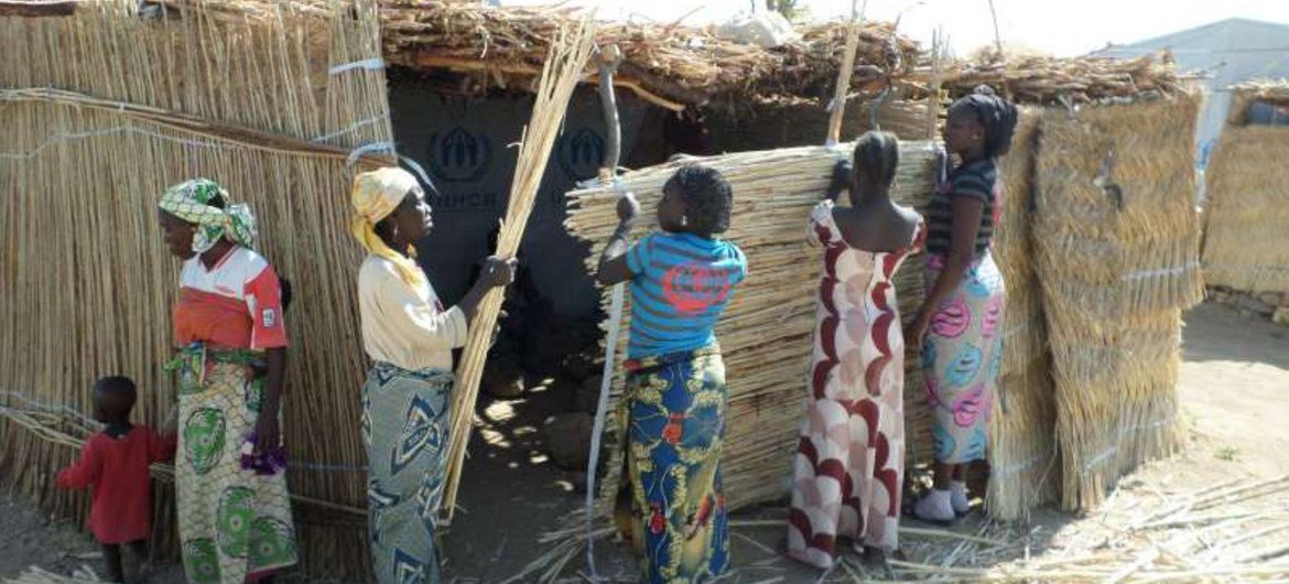 Nigerian women forced to flee their homeland work together to build a shelter at the Minawao refugee camp in Cameroon.