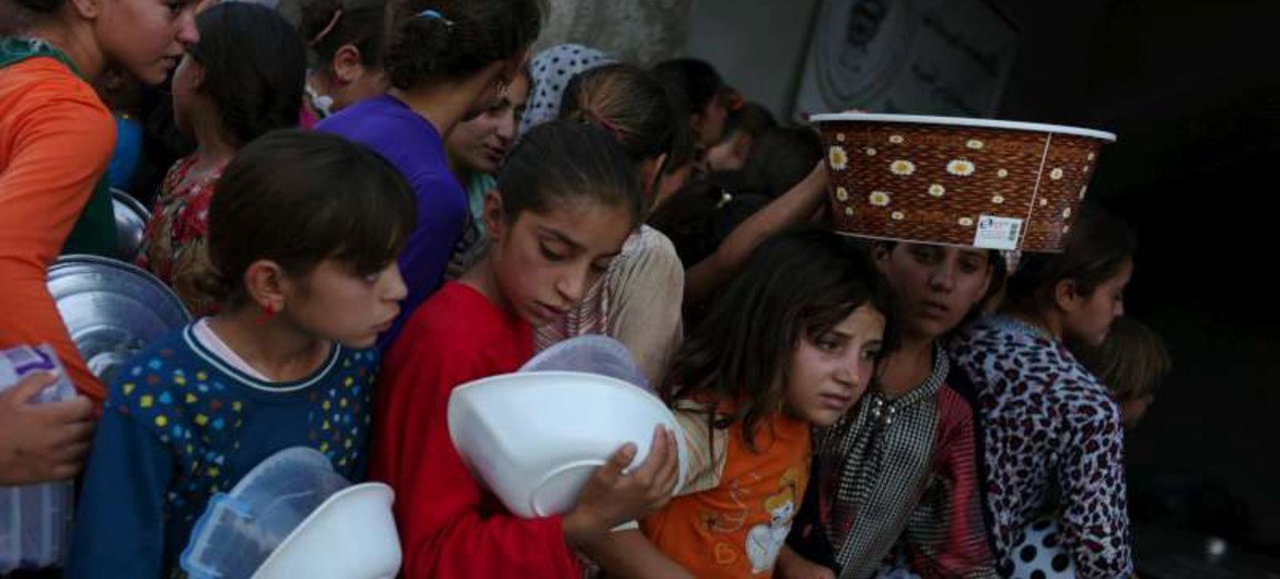 A group of internally displaced Iraqi girls queue for food at a community kitchen in a village in Iraqi Kurdistan's Dohuk governorate.