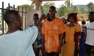 Un membre du personnel de l'Hôpital Perfectoral de Coyah en Guinée, utilise un  thermomètre « sans-contact » lors d'un dépistage d'ébola.