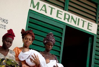 几名怀抱婴儿的妇女在几内亚东南部一所医院门口。儿基会图片/Olivier Asselin