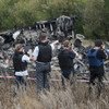 Les membres de la Mission spéciale d'observation en Ukraine de l'Organisation pour la sécurité et la coopération en Europe (OSCE)  examinent le site du crash du vol MH17 de la Malaysia Airlines en juillet 2014.
