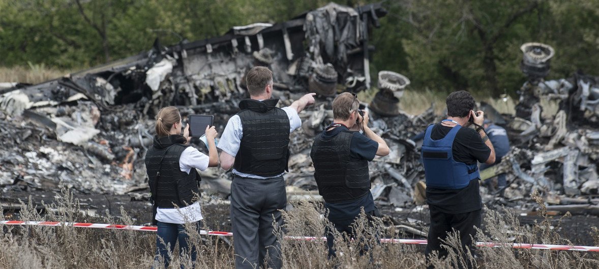 Members of the 	Organization for Security and Cooperation in Europe (OSCE) Special Monitoring Mission to Ukraine examine the MH17 crash site in July 2014.