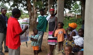 Une équipe de volontaires dans le village de Gbaneh Bana, en Sierra Leone, discute de la prévention contre Ebola avec une famille. Photo OMS/S. Gborie