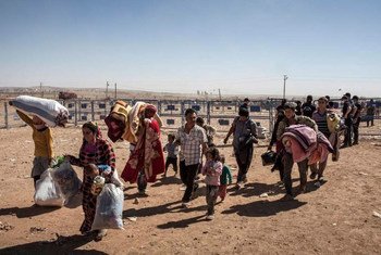 Syrian Kurdish refugees cross the border into Turkey after fleeing fighting around the city of Kobane in north-east Syria.