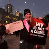 Активит с плакатом «ВИЧ - это не преступление» Фото ЮНЭЙДС