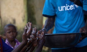 A Conakry, en Guinée, un membre d'une association enseigne aux enfants comment se laver les mains afin d'éviter la propagation de maladies, notamment Ebola. Photo UNICEF/Timothy La Rose