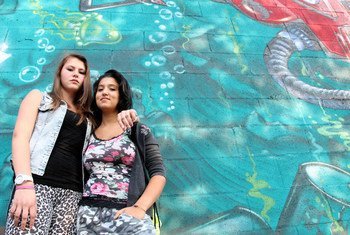 Daniela Cojocaru (left) and Chiara Dimastromatteo, both 16, stand next to a graffiti-covered wall in Turin, Italy. Daniela is originally from Moldova. Chiara does not attend school and does not have a job.