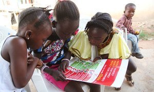 Des fillettes de la ville de Voinjama, au Libéria, regarde une affiche expliquant comment éviter la propagation d'Ebola.  Photo UNICEF/2014/Liberia/Jallanzo