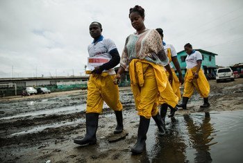 General Community Health Volunteers, who conduct contact tracing, active case finding, and general Ebola awareness, walk through West Point in Monrovia, Liberia.