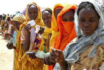 Internally displaced women hold their ration tickets while waiting for a World Food Programme distribution in Mastura, West Darfur, Sudan.