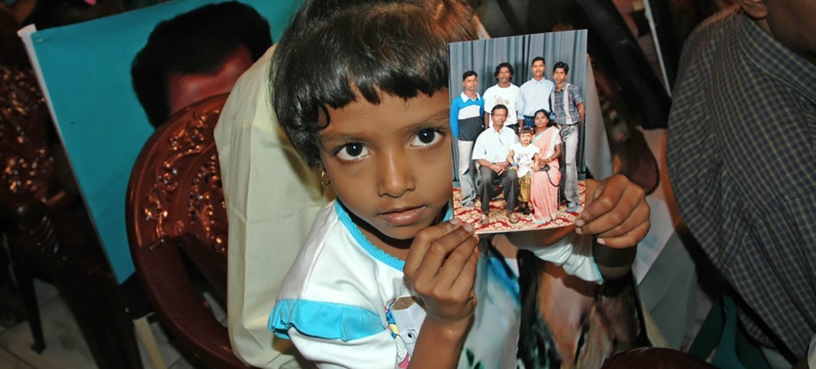 Familiares de pessoas desaparecidas durante guerra civil de 26 anos no Sri Lanka seguram suas fotos. 
