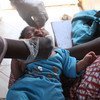 Mtoto akipokea chanjo za BCG na polio katika kitengo cha chanjo karibu na Maduka ya Matibabu ya Kati huko Freetown, Sierra Leone. 