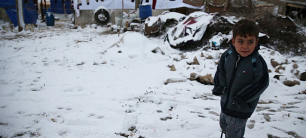 A Syrian refugee boy stands in the snow in the Faida informal tented settlement in the Bekaa Valley, Lebanon, in December 2013.