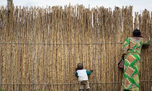 Une femme et son enfant regardent à travers la barrière en bambou d'un centre de soins à Kiwanja, une ville de la province du Nord-Kivu, en République démocratique du Congo.