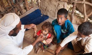 A family displaced by conflict in northern Yemen eats lunch in Al Mazraq, Hajjah.